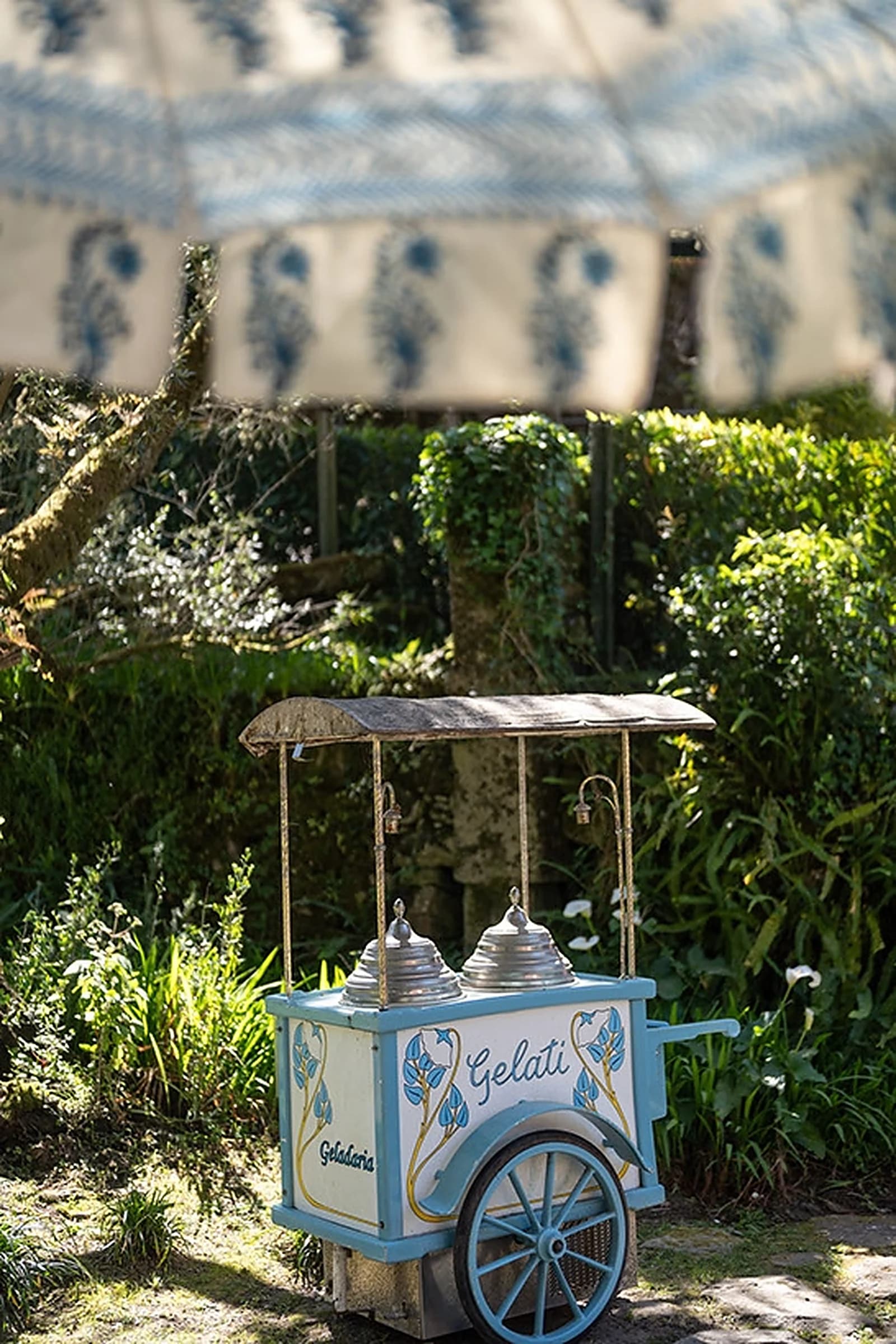 A vintage gelato cart in the garden, beneath a striped parasol