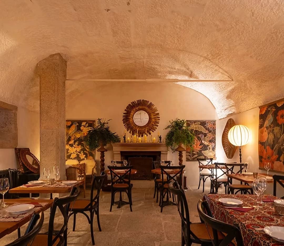 The vaulted stone dining room at Magnolia Bistro, set for dinner by firelight