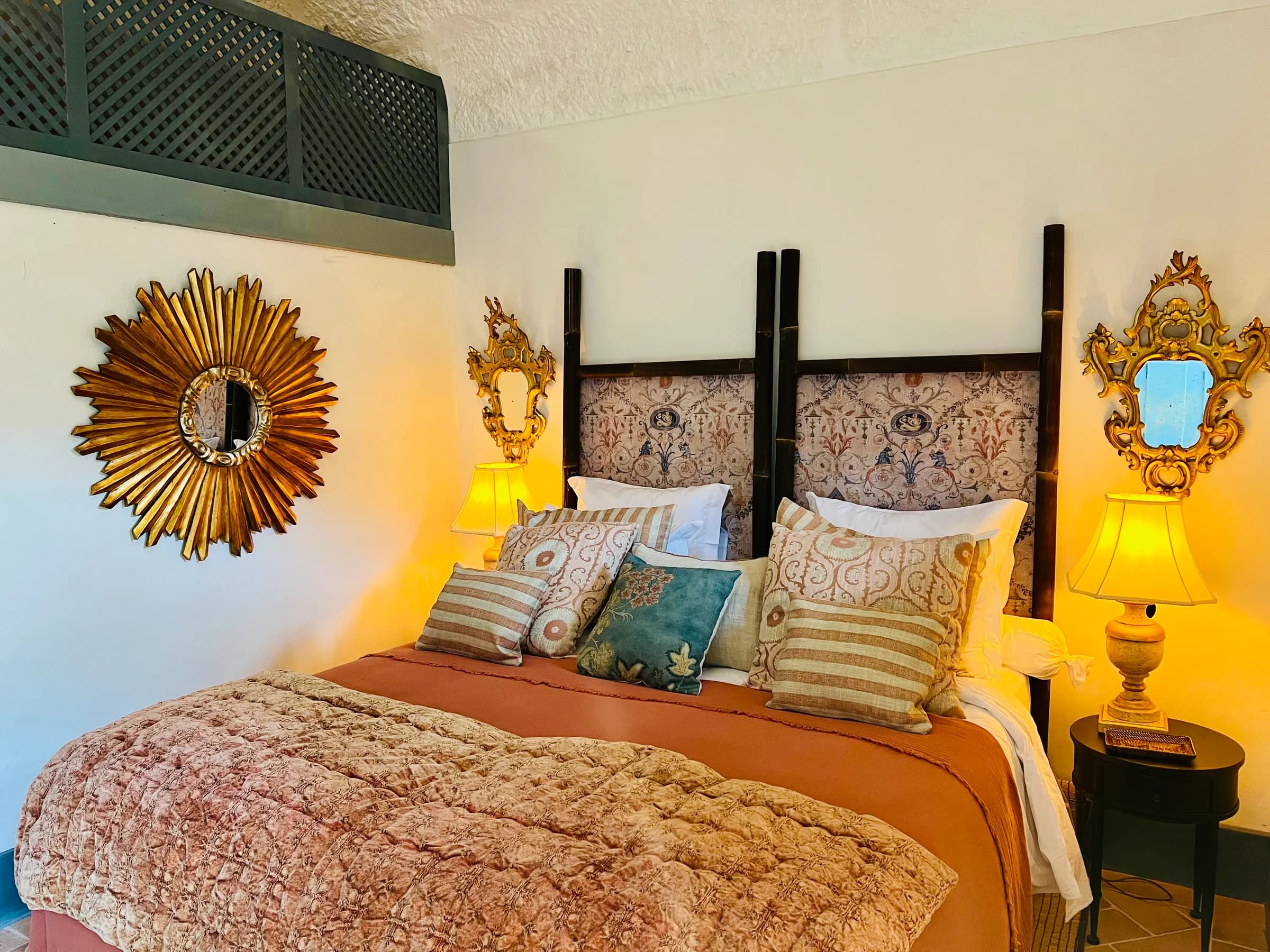 The Azalee suite — a gilt sunburst mirror above the bed