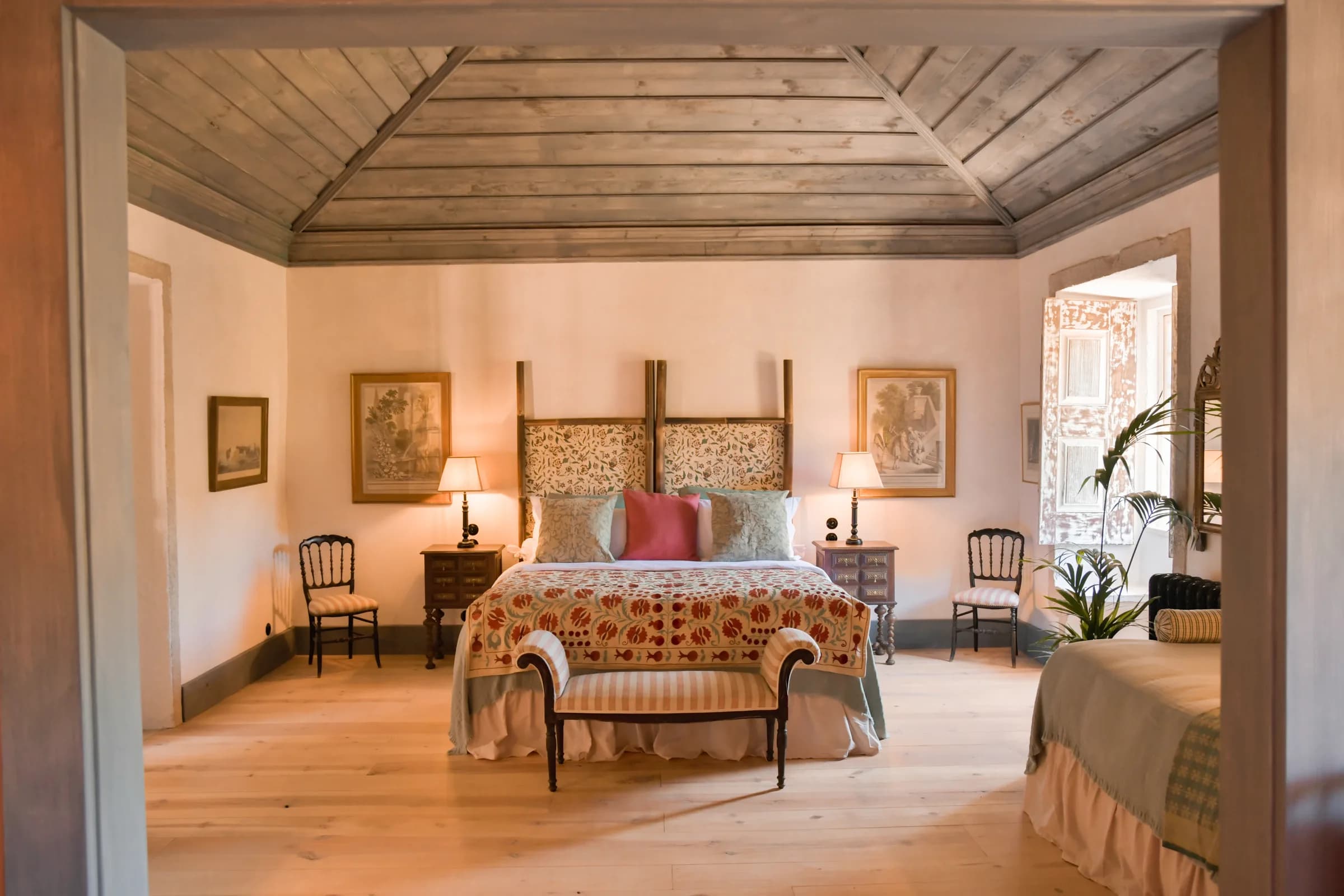 The Camelia suite — the bed beneath the painted timber ceiling