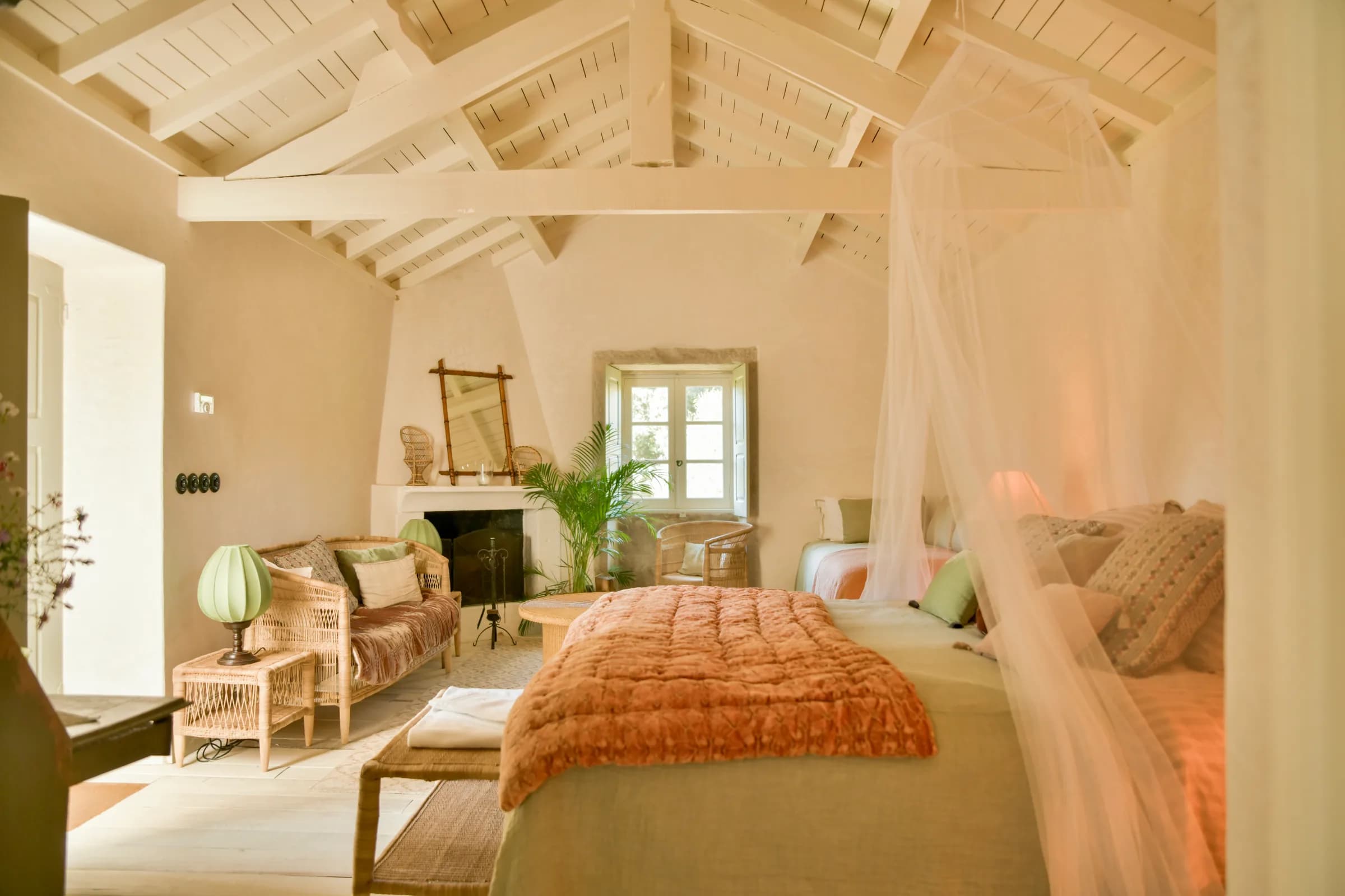 The Capucine cottage — a mosquito-net canopy beside the fireplace