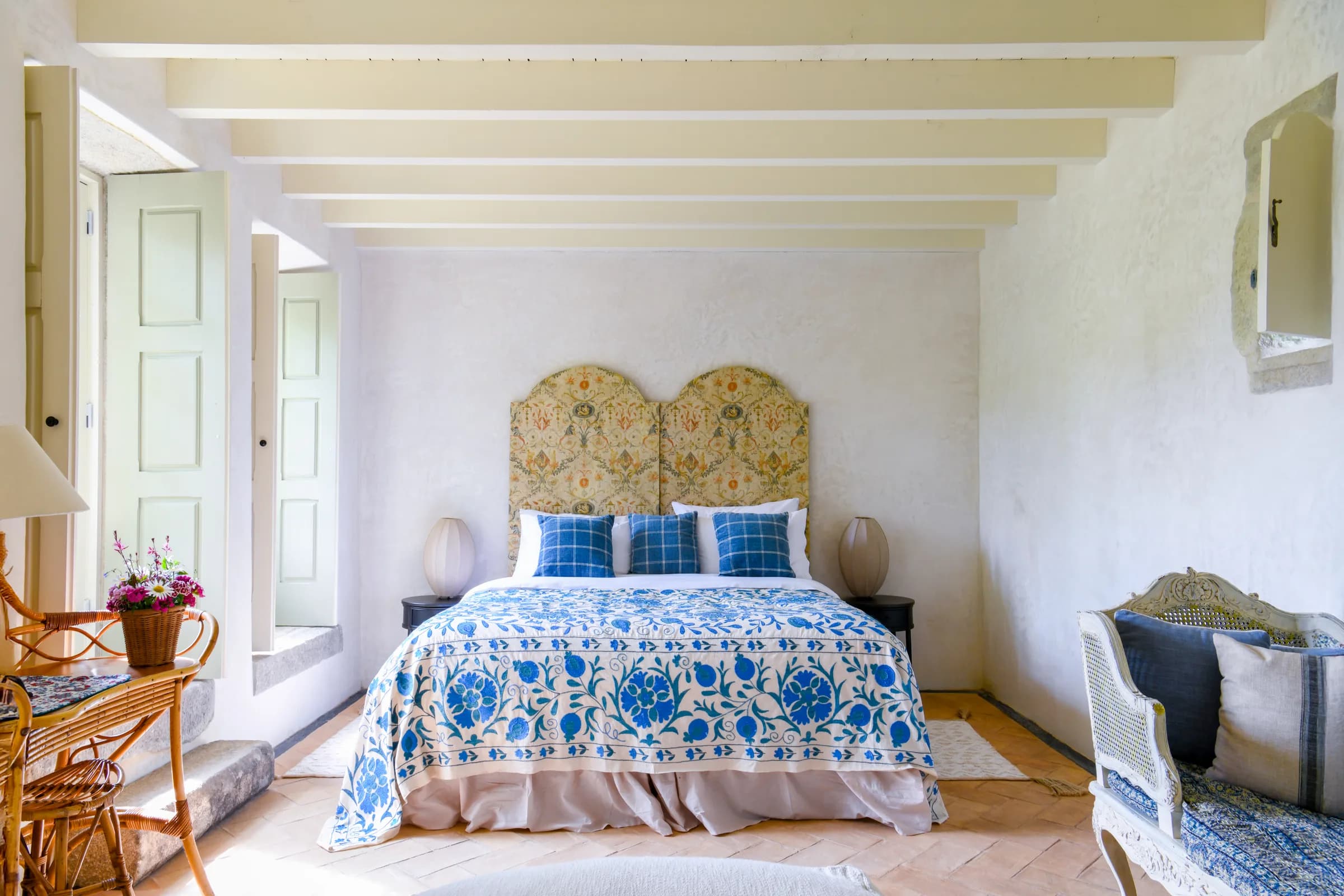 The Hortensia suite — a blue-and-white suzani bedspread beneath a floral headboard